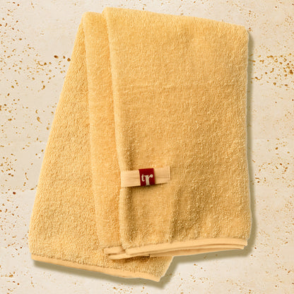 Organic hair towel in yellow with TR brand initials
